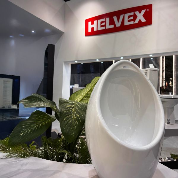 Mingitorio seco Gobi Helvex en la exposición Obra Blanca 2025 con una planta de fondo