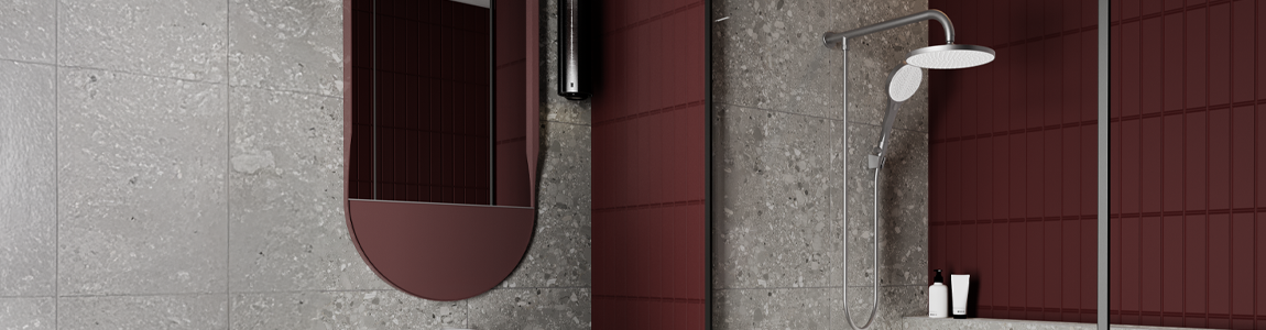 Regadera dual platino multichorro en un baño con tonos grises y rojos, con un espejo ovalado